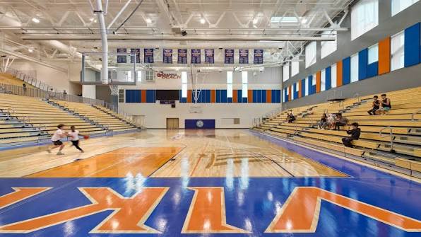 Viking gymnasium with orange and blue court, championship banners and full bleachers