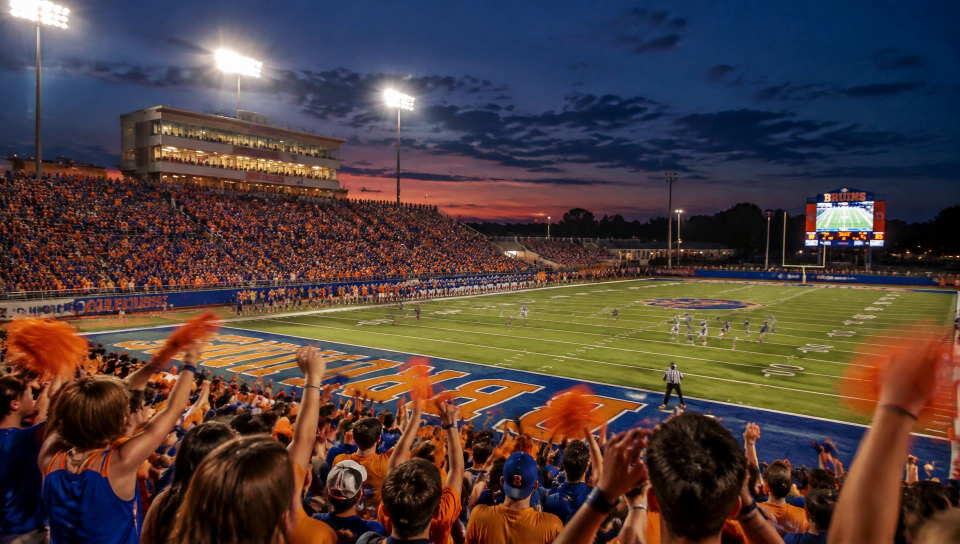 Fans in orange and blue filling the stadium on a Friday night